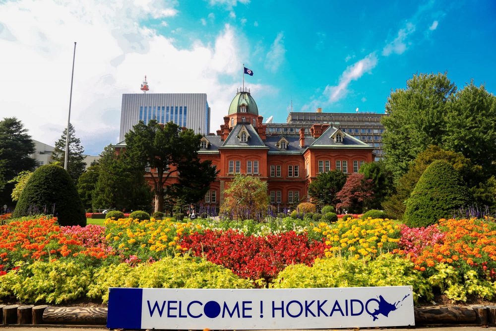 Place de bem-vindo a Hokkaido com flores e um prédio ao fundo