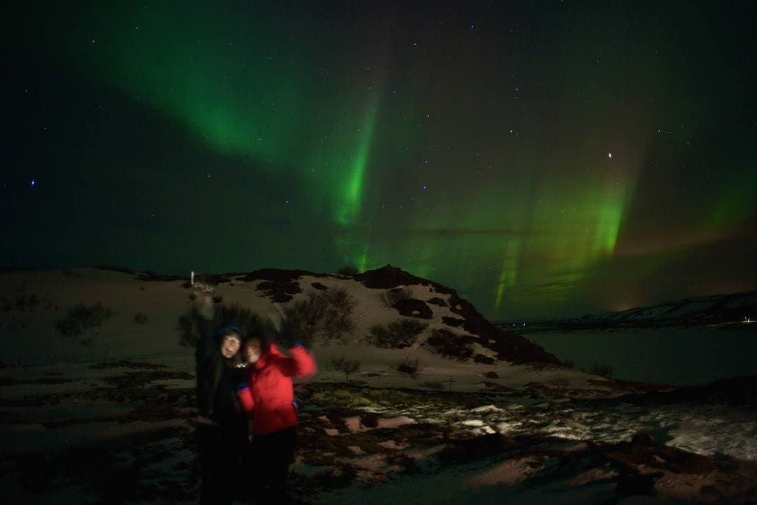 A primeira aurora boreal é algo impressionante, aqui, Lalai Persson como um pontinho vermelho em meio às luzes do fenômeno