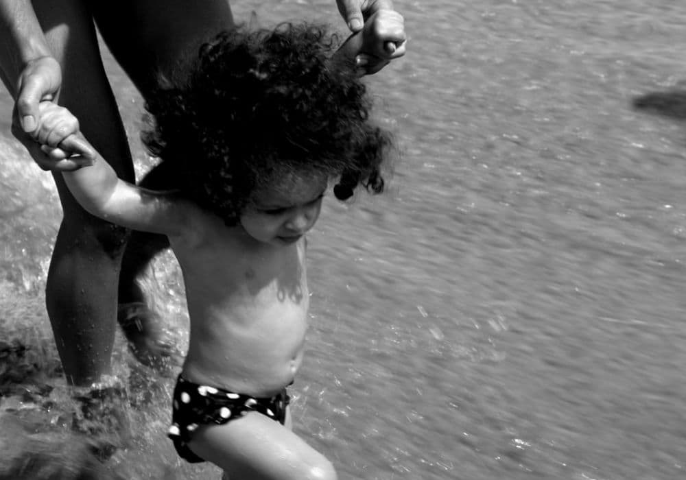 criança jogando no mar em Salvador