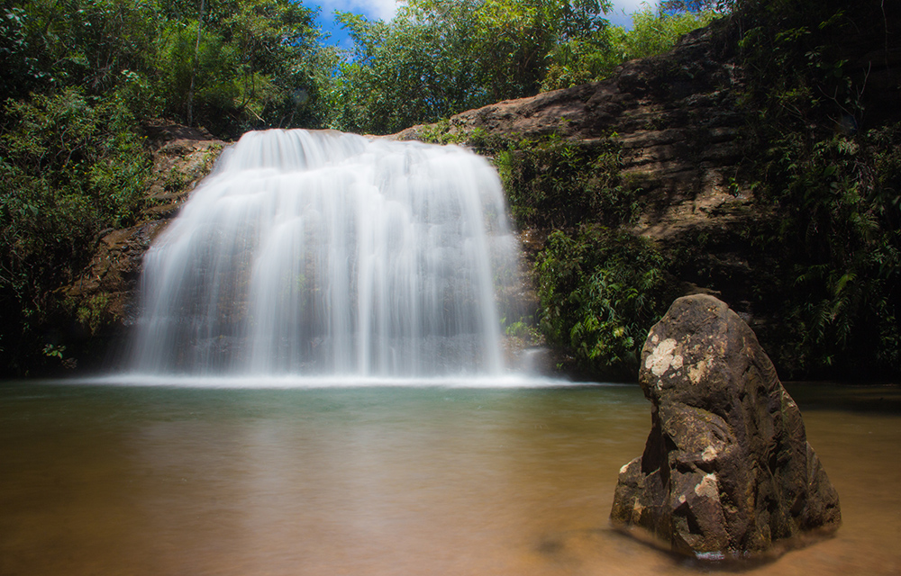 Cachoeira com vegetação ao fundo