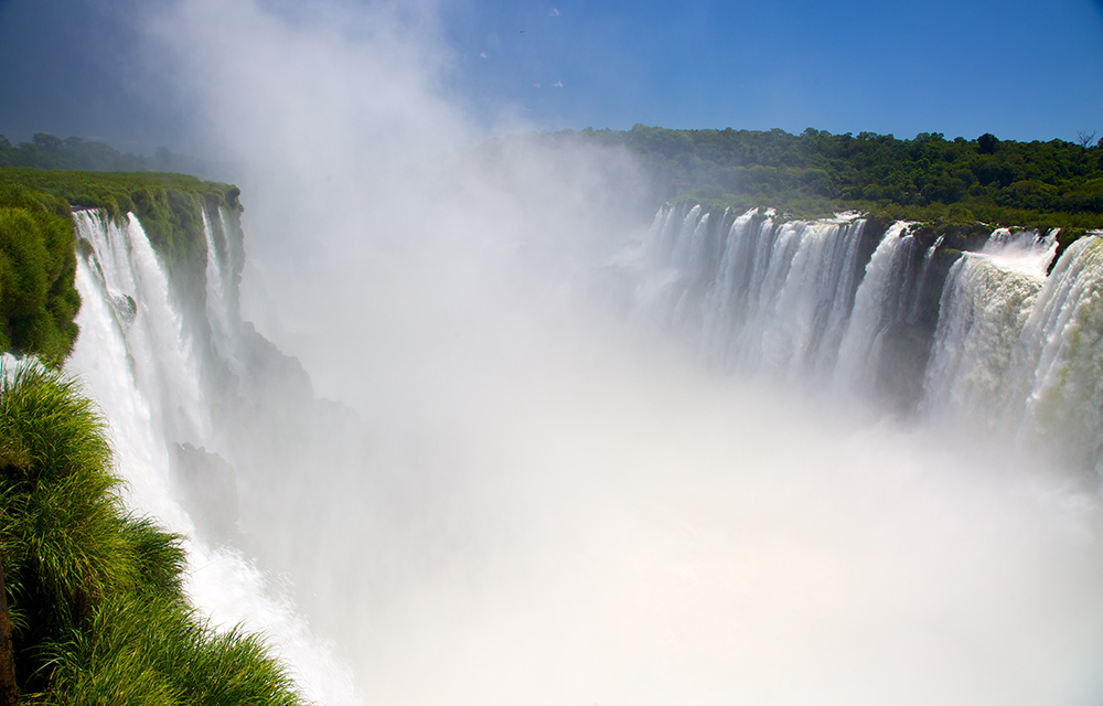 Cataratas e muito vapor d'água em meio à vegetação