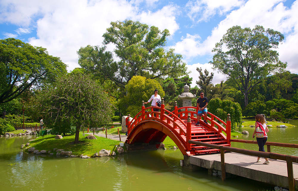 Pequena ponte vermelha sobre um laguinho no Jardim japonês