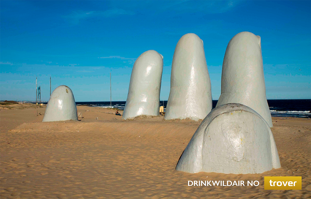 monumento em forma de mão saindo da areia