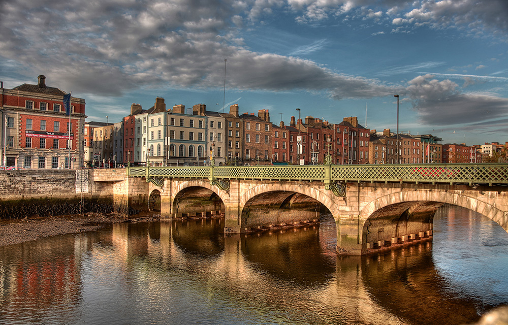 Ponte sobre rio com prédios de Dublin ao fundo