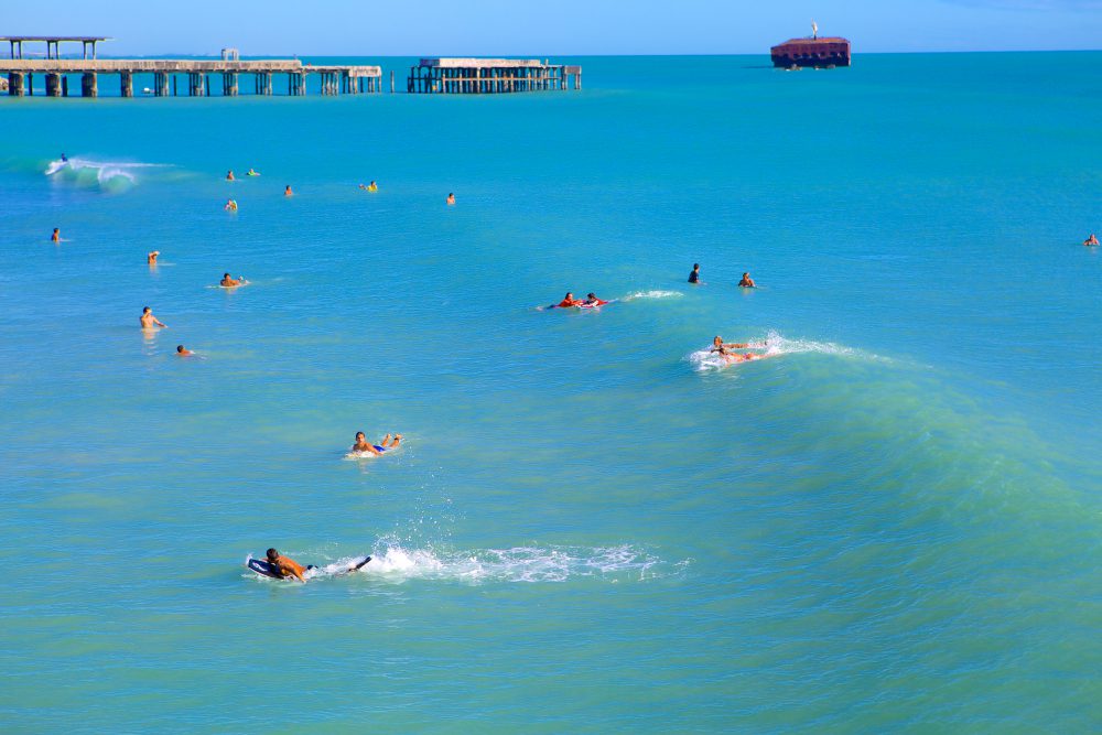 Mar em Fortaleza com diversas pessoas nadando