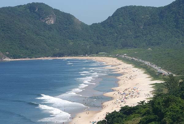 A extensa praia, fora do burburinho da zona sul e rodeada de natureza